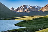 Kol-Ukok Bergsee bei Sonnenaufgang,umgeben von grünen Bergen unter blauem Himmel,Kirgisistan,Zentralasien,Asien