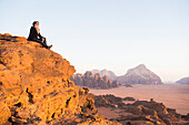 Frau genießt den Sonnenuntergang in der Wüste Wadi Rum,UNESCO-Welterbe,Jordanien,Naher Osten