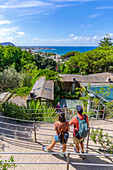 Blick auf Mann und Frau im Botanischen Garten Giardini la Mortella und Forio im Hintergrund,Forio,Insel Ischia,Kampanien,Italien,Europa