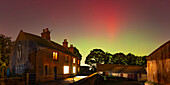 View of Northern Lights (Aurora borealis) and farmhouse near the village of Glapwell, Bolsover, Derbyshire, England, United Kingdom, Europe