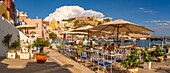 Blick auf Restaurants in Marina di Corricella und die Kirche Santa Maria delle Grazie im Hintergrund,Procida,Phlegräische Inseln,Golf von Neapel,Kampanien,Süditalien,Italien,Europa