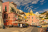 Blick auf das Restaurant in Marina di Corricella und die Kirche Santa Maria delle Grazie im Hintergrund,Procida,Phlegräische Inseln,Golf von Neapel,Kampanien,Süditalien,Italien,Europa