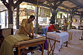 Workers applying wax-resist using a copper plate stamp (cap), Wirakuto batik workshop, Pekalongan, Java island, Indonesia, Southeast Asia, Asia