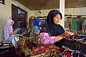 Women using a pen-like tool (canting), to apply liquid hot wax in the batik-making process, Wirakuto batik workshop, Pekalongan, Java island, Indonesia, Southeast Asia, Asia