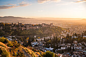 Hazy orange red sunset over Granada viewed from San Miguel Alto over the Alhambra and Albaicin, Granada, Andalusia, Spain, Europe