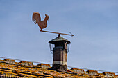 A metal weathervane rooster in the medieval walled town of Monteriggioni, Sienna, Tuscany, Italy.