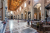 Rome, Italy, July 22 2017, Visitors admire the ornate architecture and sculptures inside San Giovanni in Laterano basilica, showcasing rich history and artistry.