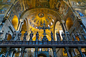 The silver and bronze crucifix on the Gothic altar screen in St. Mark's Basilica in Venice, Italy. On either side are statues of the Virgin and the Twelve Apostles.