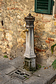 Ein Wasserbrunnen in der mittelalterlichen Stadt Monteriggioni,Siena,Toskana,Italien.