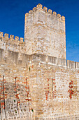 Saint George Castle stands proudly in Lisbon, showcasing its impressive fortified walls and stunning architecture under a clear blue sky.