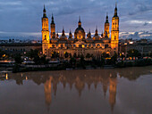 Aerial view of an illuminated El Pilar Basilica Cathedral and the Ebro River at night, Zaragoza, Spain