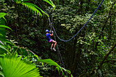 Young caucasian woman canyoning and rappelling in Costa Rica