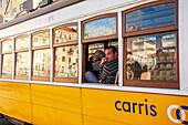 Lisbon, Portugal, March 1 2007, A man enjoys a tram ride in Figueira Square, experiencing the vibrant atmosphere of Lisbon's streets.