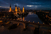 Aerial view of an illuminated El Pilar Basilica Cathedral and the Ebro River at night, Zaragoza, Spain