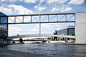 Die Fußgängerbrücke überspannt die Spree und verbindet zwei prominente zeitgenössische Gebäude des Bundestages in Berlin.