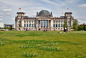 Berlin, Germany, July 29 2009, People gather on the green lawn in front of the historic Reichstag building under a clear blue sky in Berlin.