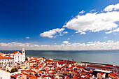 Stunning landscape of the Tejo estuary and Santo Estevao Church in Lisbon, Portugal, under a bright blue sky. The combination of water and architecture creates a tranquil and picturesque scene.