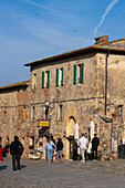 Tourists on the Piazza Roma in the medieval walled town of Monteriggioni, Sienna Province, Italy.