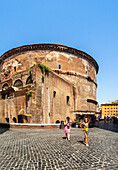 Rome, Italy, July 2017, Visitors stroll past the historic rear of the Pantheon, surrounded by the vibrant atmosphere of Rome on a sunny day.