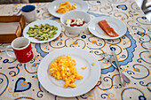 Ein köstliches hausgemachtes Brunch-Set in Sevilla mit Rührei,geräuchertem Lachs,Avocado,Tomatensalat und einer warmen Tasse Kaffee - ein erfrischendes und einladendes Mahl.