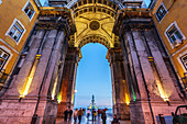 Lisbon, Portugal, March 1 2007, Pedestrians wander through the Augusta street triumphal arch at dusk, leading to the vibrant Praça do Comércio in Lisbon.