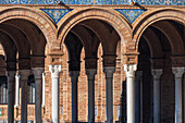 Close up of the intricate arches and columns of Plaza de Espana, showcasing the beautiful architecture of Seville, Spain.