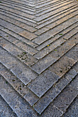 A chevron design in the flagstone paving in the medieval walled town of Monteriggioni, Sienna, Tuscany, Italy.