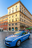 Rome, Italy, July 2017, A police car stands near Piazza di Spagna, while visitors explore the vibrant square filled with activity.