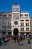 Tourists in front of St. Mark's Clocktower, built in 1499 A.D., in St. Mark's Square in Venice, Italy.