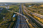 Aerial view of a bridge over the train tracks at sunset