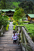 Young girl walking down the wooden stairs of a mountain hotel in Colombia