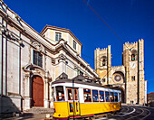 Lisbon, Portugal, March 1 2007, A yellow tram travels past the historic San Antonio de Lisboa church and the majestic Lisbon cathedral in the heart of the city.