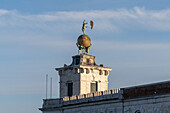 A statue on the point of Punta della Dogana in Venice, Italy. Two atlases supporting a gilded globe with a weathervane representing Fortuna, completed in 1677 by Bernardo Falcone.