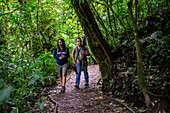 George of the Cloud Forest, guide and specialist, guides a young woman through Monterey cloud forest during fauna tour, Costa Rica