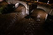 Nachtansicht eines reichlich fließenden Ebro,der nach der Dana unter der Steinernen Brücke hindurchfließt,Zaragoza,Spanien