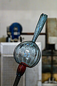 The partially-completed glass piece attached to the blowpipe in a glassblowing demonstration in Venice, Italy.