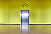 Berlin, Germany, July 29 2009, A sleek elevator entrance is set against a vibrant yellow wall inside the House of World Cultures in Berlin.