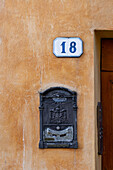 A post box on a stuccoed wall in the medieval walled town of Monteriggioni, Sienna, Tuscany, Italy.