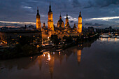 Aerial view of an illuminated El Pilar Basilica Cathedral and the Ebro River at night, Zaragoza, Spain