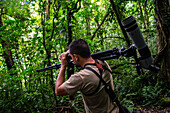 George of the Cloud Forest, guide and specialist, using binoculars to spot wildlife in Monterey cloud forest during fauna tour, Costa Rica