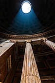 Rome, Italy, July 2017, A beam of sunlight pierces the Pantheon dome, highlighting the majestic Corinthian columns in Rome's historic architecture.