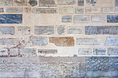 Fragments from ancient catacombs displayed in the narthex of Santa Maria in Trastevere, revealing historical inscriptions and carvings.