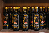 Bottles of extra virgin olive oil for sale in the gift shop of an olive oil processing mill in Italy.