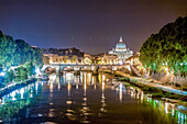 Der Tiber spiegelt die Lichter der Stadt,während die Vatikanstadt bei Nacht in Rom,Italien,majestätisch dasteht.