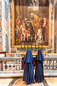 Rome, Italy, July 22 2017, A couple of nuns quietly admire Pope John XXIII in St. Peter's Basilica, in front of the Altar of St. Jerome, painting by Domenichino (1614), in Rome, Italy.