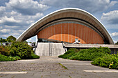 The House of World Cultures showcases its unique architecture amidst lush greenery in central Berlin, inviting cultural exploration.