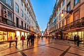 Lisbon, Portugal, March 1 2007, Pedestrians enjoy a leisurely walk along Augusta Street as dusk falls over Lisbon's bustling Baixa district, filled with charming shops.