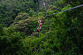 Junge kaukasische Frau hat Spaß bei einer Canopy-Tour in Costa Rica