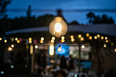 A dreamy setting of an outdoor wedding party in Malaga, Spain with glowing lights creating a magical evening ambiance.