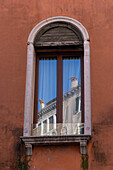 Chimneys reflected in a window in Venice, Italy.